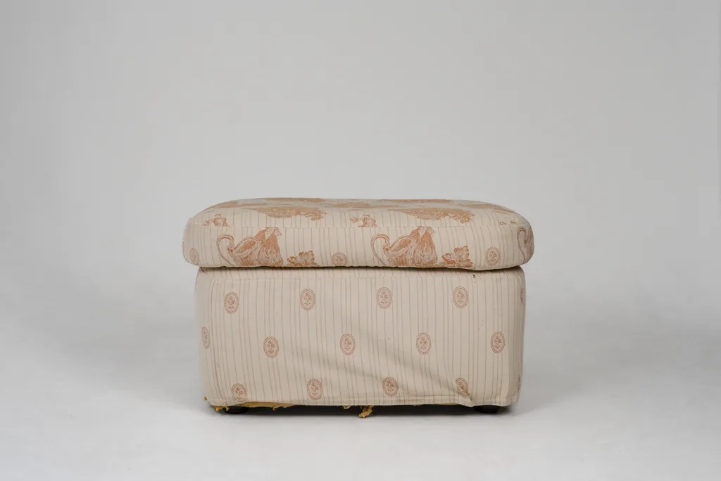 Neu gepolsterter Hocker mit hellem Stoffbezug und floralem Muster – individuelles Tapeziererhandwerk von apolsteria in Saalfelden.