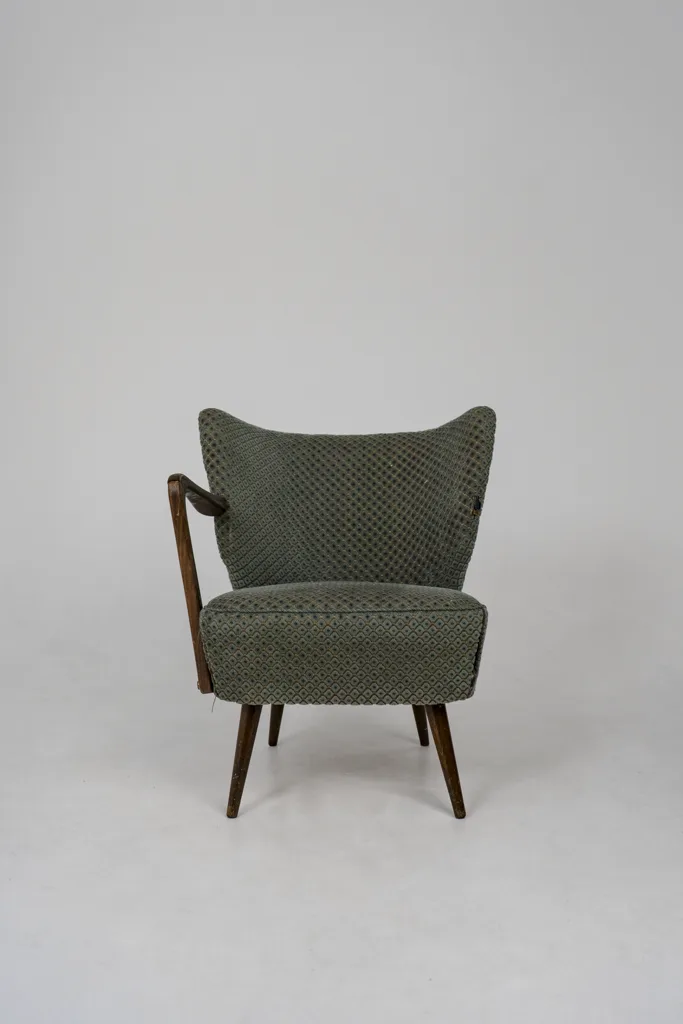 Neu gepolsterter Vintage-Sessel mit grün gemustertem Stoff und Holzarmlehne – individuelle Möbelaufarbeitung von apolsteria in Saalfelden.