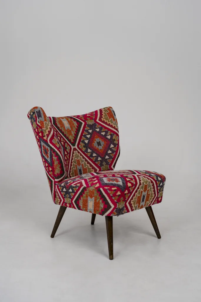 Neu gepolsterter Cocktailsessel mit auffälligem Ethno- und Kelim-Muster in Rot- und Orangetönen – individuelles Tapeziererhandwerk von apolsteria in Saalfelden.