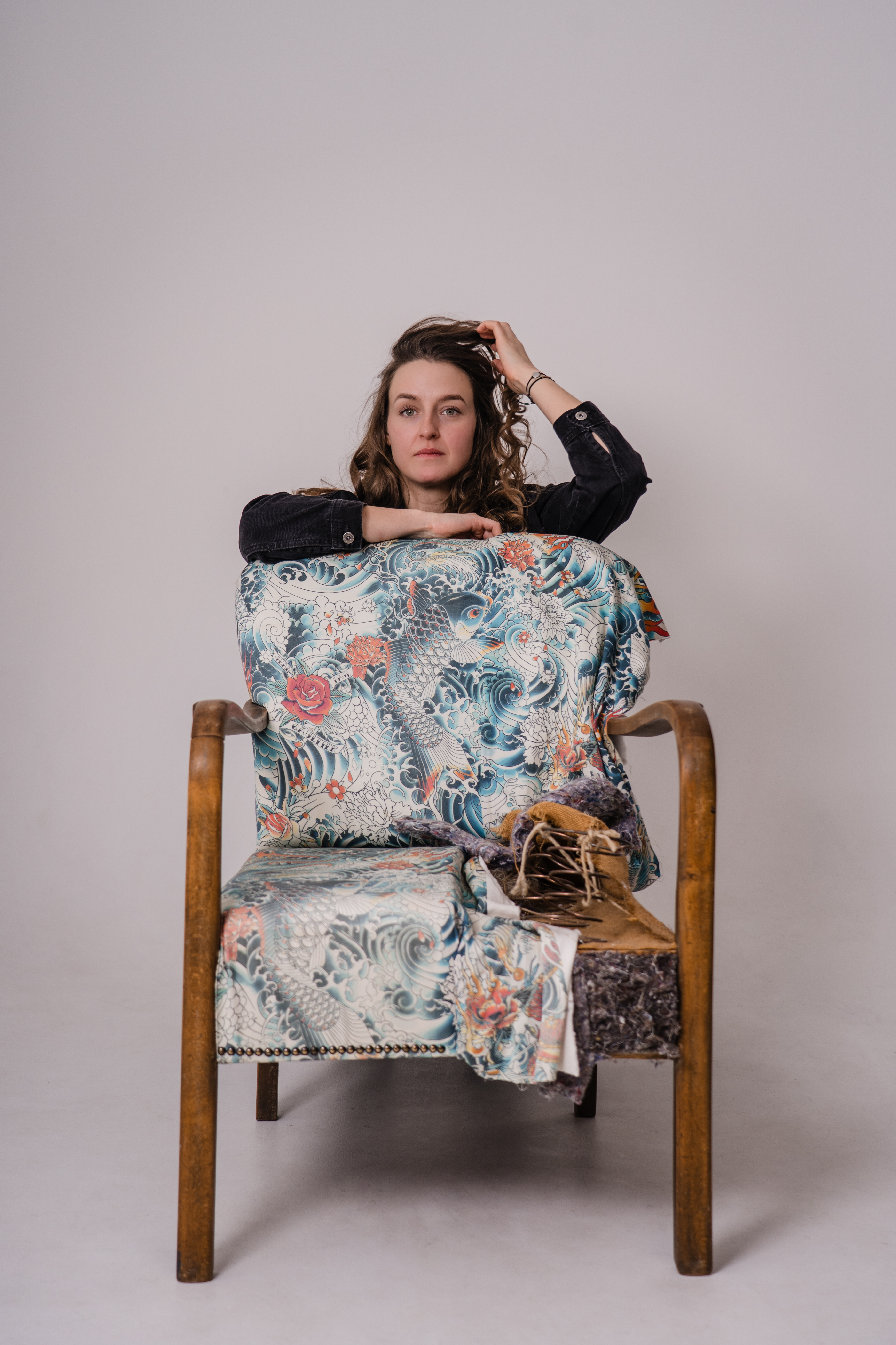 Sara Szulc von apolsteria präsentiert einen neu gepolsterten Holzsessel mit auffälligem Designstoff. Die Tapezierermeisterin aus Saalfelden verbindet traditionelles Handwerk mit modernem Interior Design.